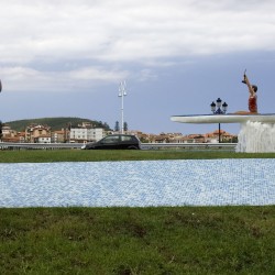 Una turista fotografía la escultura que homenajea el Descenso de Sella
