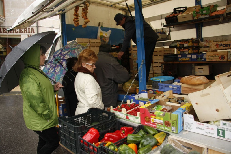 Varias vecinas esperando para comprar en un puesto de frutas del mercado semanal, que se celebra los sábados en la plaza de Laverde Ruiz.
