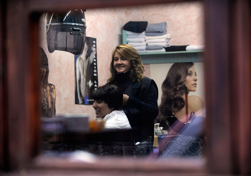 Paula Famos peina a Ángela Calvo en su peluquería.