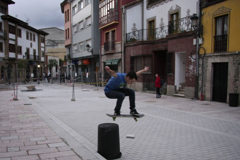 Un joven salta con su monopatín en la calle San Pelayo
