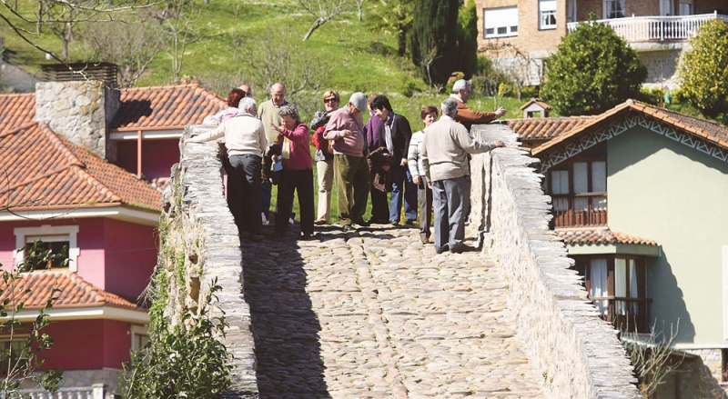 Un grupo de turistas, encaramado en la parte más alta del «puente romano», el símbolo más fotografiado de Cangas de Onís