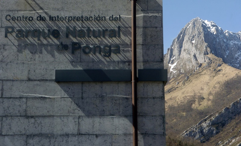 El cartel anunciador del Centro de Interpretación del parque natural de Ponga, con el Tiatordos detrás.