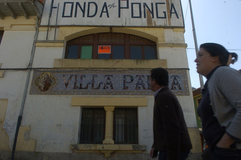 Dos transeúntes pasan ante Villa Padua, casa de indianos junto a la Fonda de Ponga.