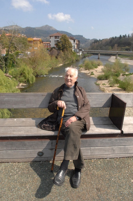 Ramón Llamedo, "El Roque", sentado en la pasarela sobre la confluencia del Piloña y el Sella.