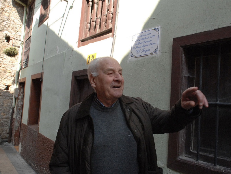 Ramón Llamedo, ante la placa que señaliza su casa natal, en la calle del Serruchu.