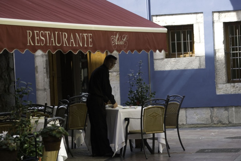 La preparación de las mesas en la terraza de un restaurante en la zona del puerto.