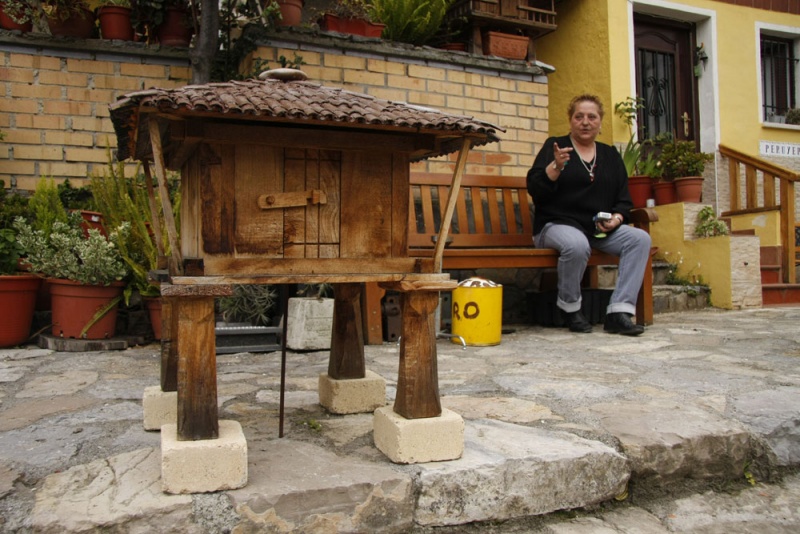 Gema Pérez, ante su casa en el barrio de Pumarín, señala uno de los hórreos en miniatura que hacía su marido, Rubén García.