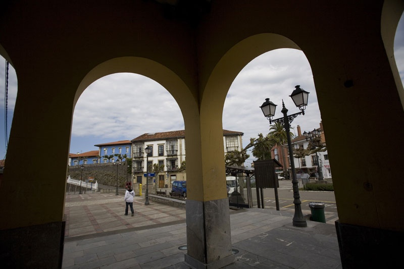 La plaza de España, vista a través de los soportales de la iglesia.