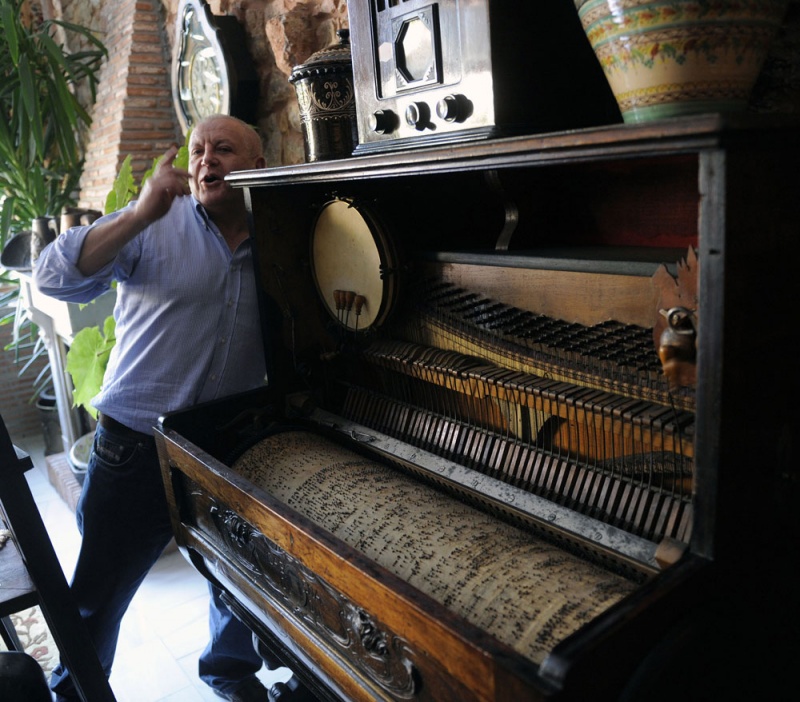 Juan Rodríguez da cuerda a una pianola en los apartamentos La Pontiga.