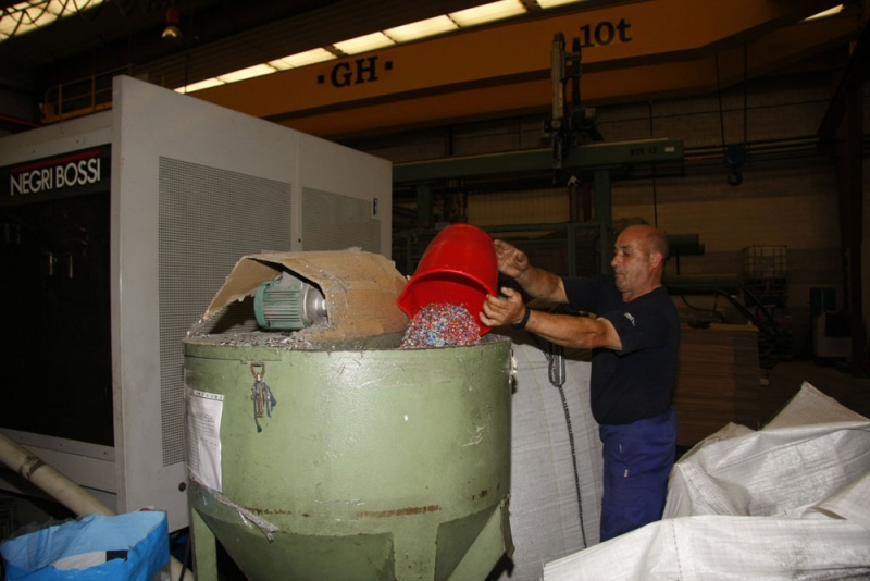 Julio Urraca echa plástico reciclado en un recipiente, en General de Juguetes.