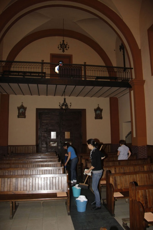 Varias mujeres limpian la iglesia de Villamayor.